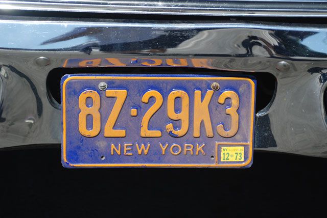 A bit of research shows that New York never used this sort of plate numbering, something fairly common of prop license plates. The state name and plate number also in the wrong typeface, as per most prop plates.